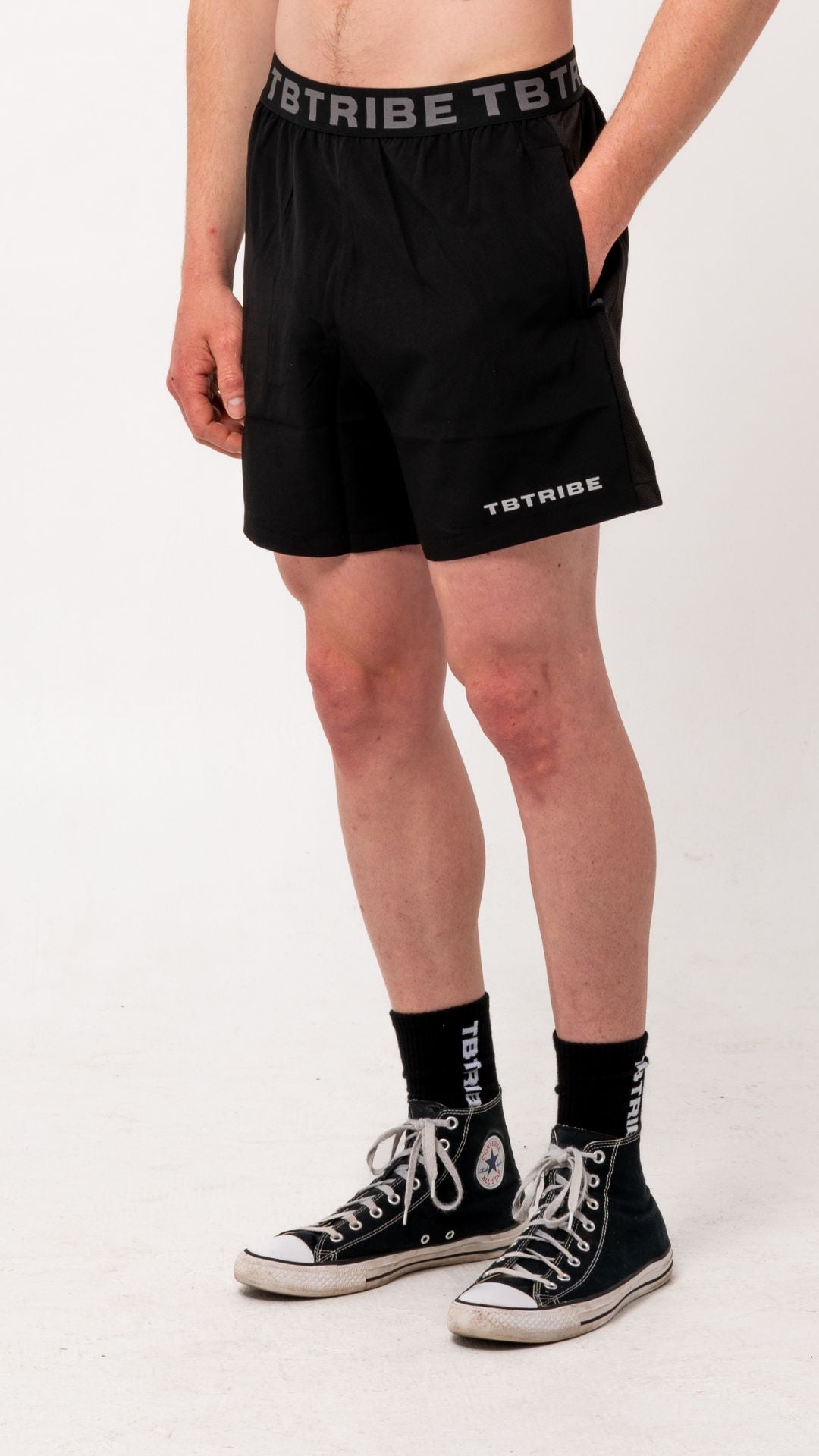 Black gym, training shorts with branded TB Tribe elastic waist band. Features side pockets with zippers, mesh panels on the side for ventilation and small TB Tribe logo on left leg